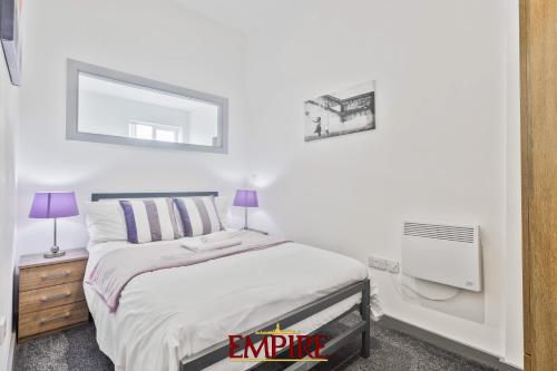布赖尔利希尔Modern One Bedroom Apartment Brierley Hill的白色卧室配有床和镜子