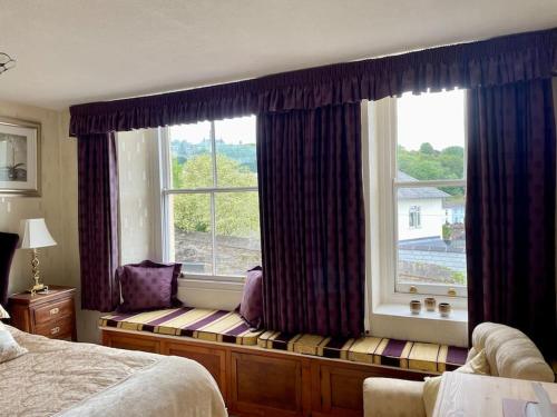 达特茅斯Elim in Dartmouth with stunning River Dart view的卧室的靠窗座位,设有大窗户