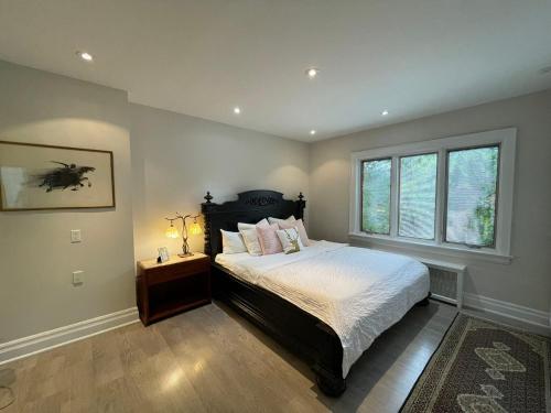多伦多Private Suite in Forest Hill with full kitchen and parking的一间卧室设有一张大床和一个窗户。