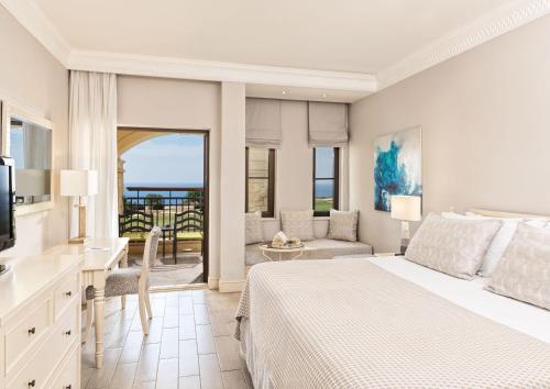 库克里亚Atlantica Aphrodite Hills Hotel的一间卧室设有一张床和一间客厅。