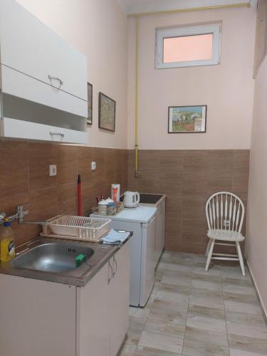 鲁马Apartman Central的一个带水槽和椅子的小厨房