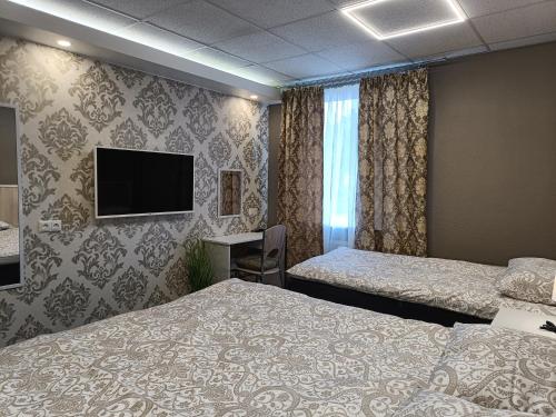 纳尔瓦APARTHOTEL的酒店客房设有两张床和一台平面电视。