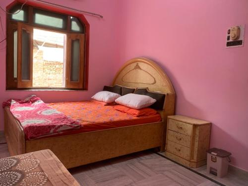 比卡内尔MOON HAVELI的粉红色墙壁的房间里一张床位