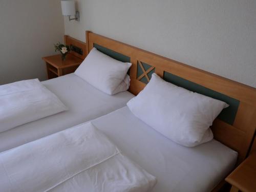 索梅拉Bocksbeutelherberge的两张带白色枕头的床,彼此相邻