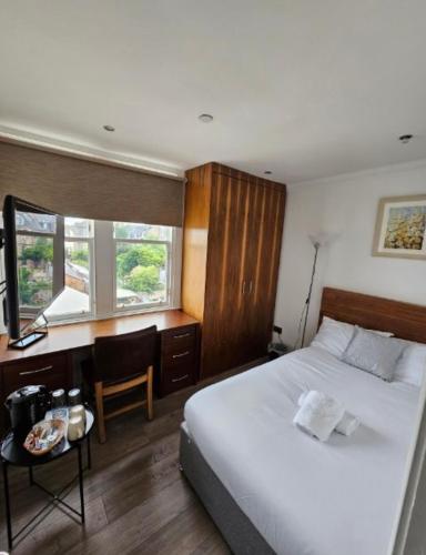 爱丁堡Cosy Double Room City Centre的卧室配有白色的床、书桌和窗户。