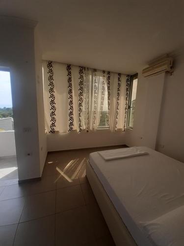 希马拉Borsh Amantius Apartments的一间卧室配有床和带窗帘的窗户