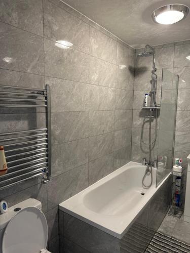 KentDartford Luxurious House with Parking - Netflix - Wi-Fi的带浴缸、卫生间和淋浴的浴室。