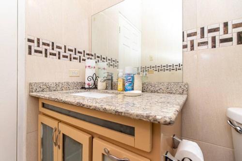 Spanish TownJ&R Sunshine Retreat的浴室的柜台设有水槽和镜子