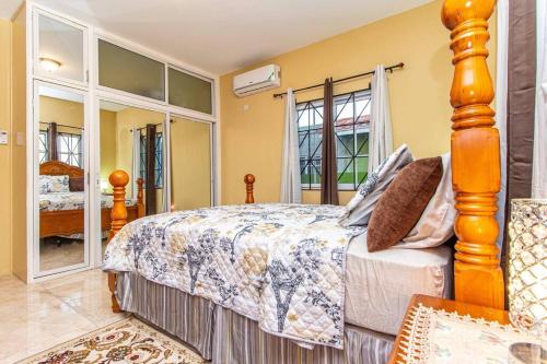 Spanish TownJ&R Sunshine Retreat的一间卧室设有一张大床和一个大窗户