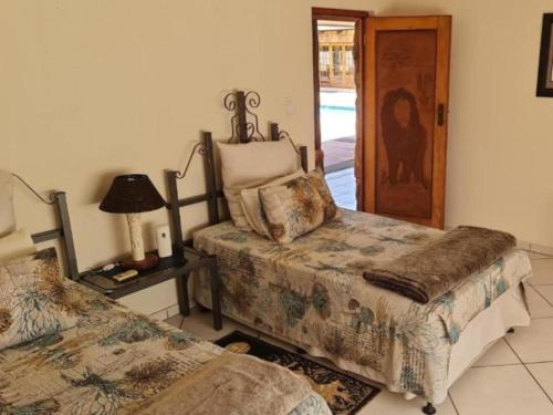 MtubatubaThe Sanctuary - Self Catering Accommodation的一间卧室设有两张床、一盏灯和一扇门