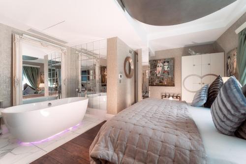 伦敦卡玛桑顿SOHO酒店的一间大卧室,配有一张大床和一个浴缸