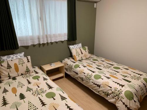 奈良Guesthouse Kaede Annex的一间卧室设有两张床和窗户。