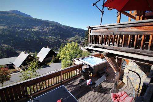 瓦尔Chalet with Ski Slope Views, Jacuzzi & Cinema Room的房屋甲板上的热水浴池