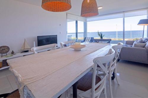 埃斯特角城Oceana Suites en Lumiere, frente a playa Mansa的客厅配有大型木桌和椅子