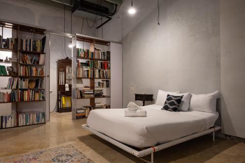 圣胡安Cozy Studio Gem - Old San Juan - Near Attractions的卧室配有白色大床和书架