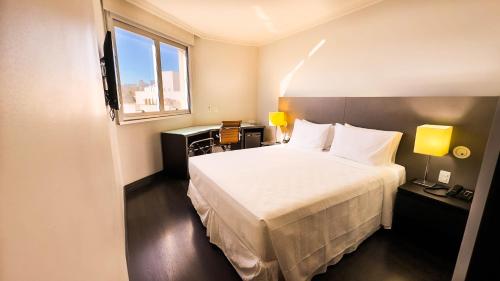 贝洛奥里藏特Hotel Gran Vivenzo Belo Horizonte的酒店客房设有床和窗户。