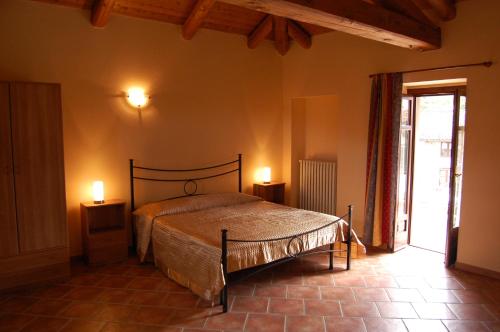 蒙蒂罗奥比塞拉依尼农庄酒店的一间卧室配有床,两台桌子上有两个灯