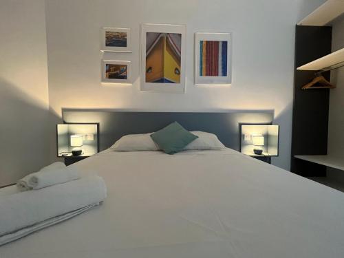彭布罗克Modern and Spacious 3 Bedroom Apartment的一间卧室配有一张带两盏灯的大型白色床。