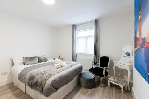 伦敦Large Studio Apartment 30 mins to Oxford Street (B)的一间卧室配有一张床、一张书桌和一个窗户。