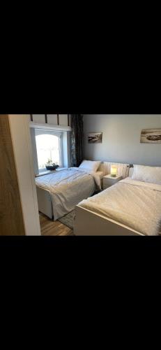 斯凯里斯The Lifeboat & Seaview Terrace的一间卧室设有两张床和窗户。