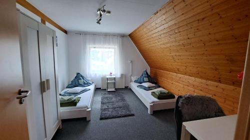 FriolzheimCosy Retreat in Friolzheim的小房间设有两张床和窗户