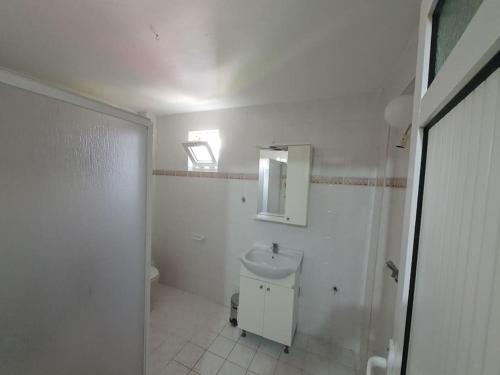 库萨达斯A Vacation House 60 m. To Seashore的白色的浴室设有卫生间和水槽。