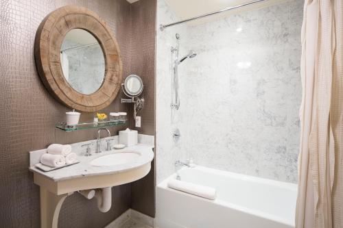 Southport德勒马南港酒店的一间带水槽、淋浴和镜子的浴室