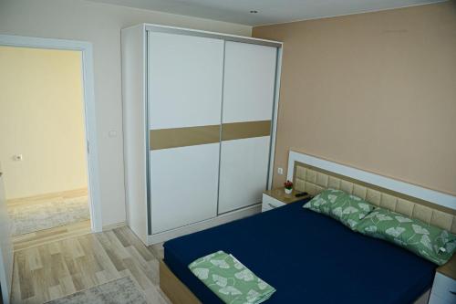 奥格尼亚诺沃Къща за гости Хаджиеви的一间卧室配有一张蓝色的床和一个大衣柜