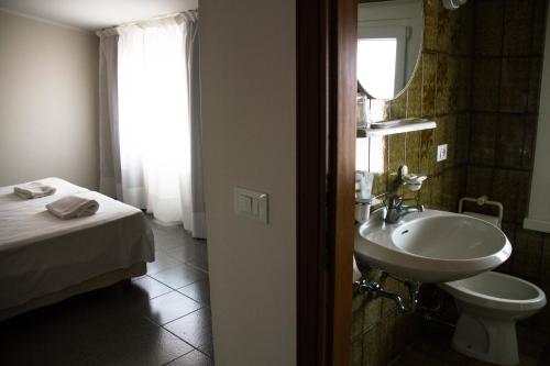 伊塞奥阿利安娜酒店的一间带水槽、床和镜子的浴室