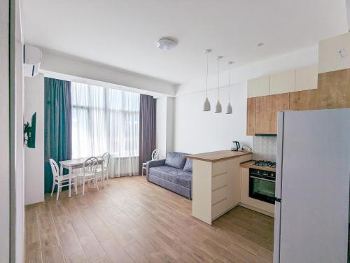 库塔伊西Brand new apartment in Kutaisi的厨房以及带沙发和桌子的客厅。