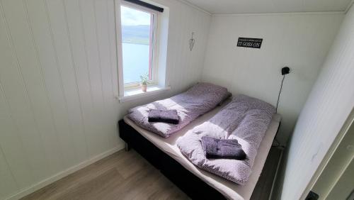 The Cozy red house with Amazing sea view的小房间设有两张带紫色毛巾的床