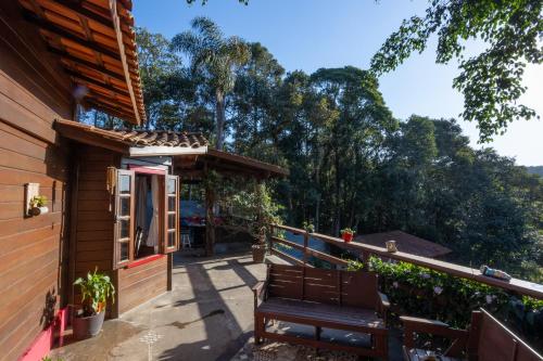 迈里波朗Cantareira - Deck House的一个带长凳和树木的房子的门廊