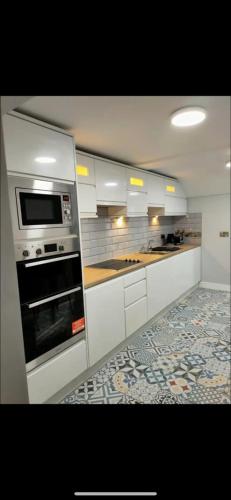 斯凯里斯The Captains Wheel and Anchor的厨房配有白色橱柜和烤箱。