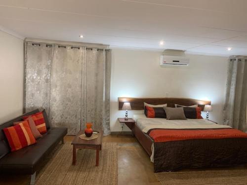 奔巴岛R A GUEST HOUSE PEMBA的一间卧室配有一张床和一张沙发