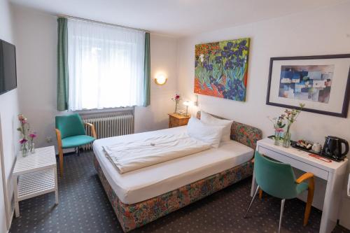 弗莱堡阿利豪斯酒店的酒店客房,配有一张床、一张桌子和椅子