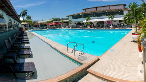布卡拉曼加Hotel San Juan Internacional的一座带椅子的大型游泳池和一座建筑