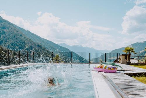 卢松贝格斯劳斯酒店的一个人在带气垫筏的游泳池游泳