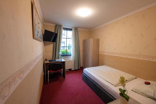 门登市政厅酒店的配有一张床、一张书桌和一扇窗户的酒店客房