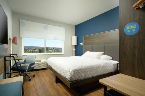 查塔努加Tru By Hilton Chattanooga Hamilton Place, Tn的一间卧室配有一张床、一张桌子和一把椅子