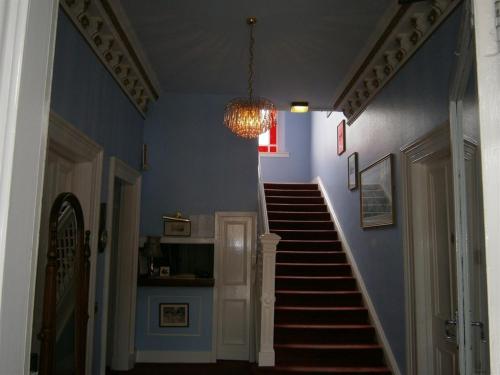 爱丁堡Dorstan House的走廊设有蓝色的墙壁和带吊灯的楼梯
