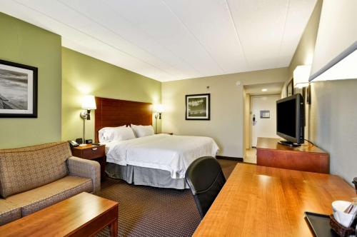 格尼芝加哥古尔尼希尔顿恒庭酒店的一间酒店客房,配有一张床和一台电视