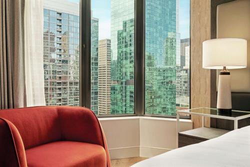 芝加哥Hilton Grand Vacations Club Chicago Magnificent Mile的卧室设有红色椅子和大窗户