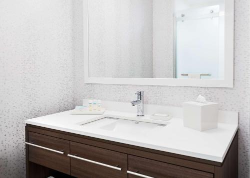 芝加哥芝加哥麦考密克广场希尔顿欣庭套房酒店 的浴室设有白色水槽和镜子