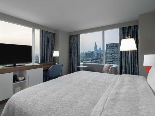 芝加哥芝加哥麦考密克广场汉普顿酒店的一间酒店客房,设有一张大床和一个大窗户