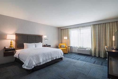 芝加哥芝加哥北站罗耀拉汉普顿酒店 的酒店客房,配有床和黄色椅子