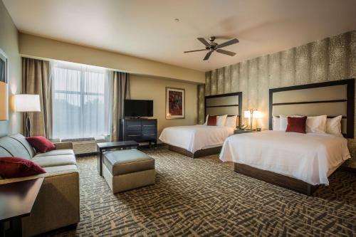 夏洛特Homewood Suites by Hilton Charlotte Ballantyne, NC的酒店客房,设有两张床和一张沙发