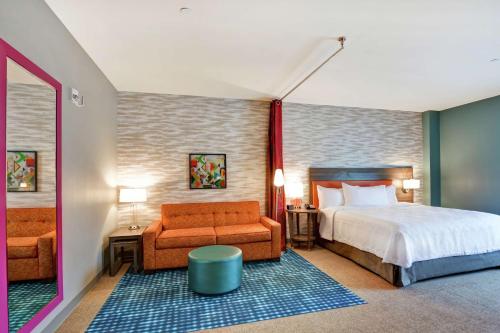 夏洛特Home2 Suites By Hilton Charlotte Piper Glen的一间卧室配有一张床、一张沙发和一把椅子