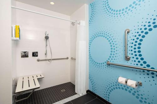 岩石丘Tru By Hilton Rock Hill, SC的浴室设有蓝色淋浴间和长凳