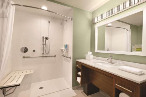 都柏林哥伦布都柏林希尔顿惠庭酒店的一间带水槽、淋浴和镜子的浴室
