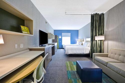 布鲁艾施Home2 Suites By Hilton Blue Ash Cincinnati的酒店客房,配有床和沙发